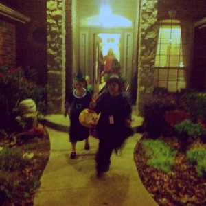 Little girls dressed as witches going door-to-door for candy